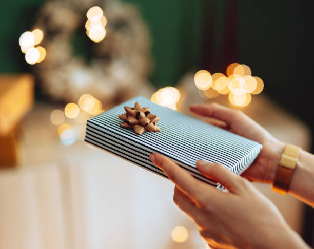 istock An Anonymous Woman Giving A Christmas Present 1431196399