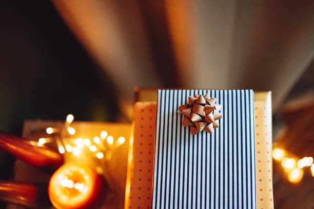 Table top view of candles and wrapped Christmas gifts in a living room.