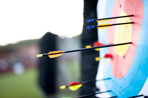 Close up on three arrows in the middle center of the target goal achieved success archery