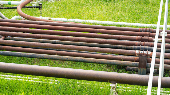 Rustic iron crude oil transfer pipeline structure at the oil refinery plant. Industrial equipment object photo.