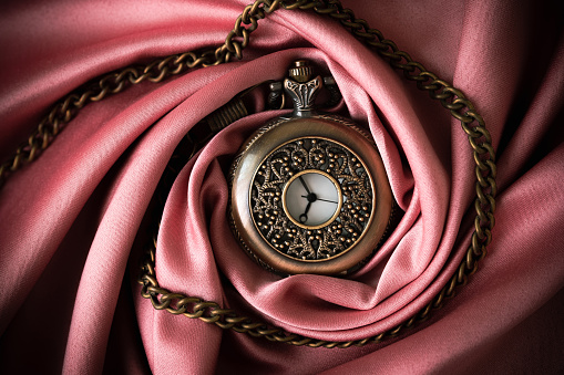 Defocus new year midnight. Close-up of old gold-plated pocket watch. Vintage pocket watch on black background. New Year's at midnight. Closeup. Out of focus.