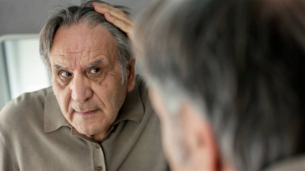 istock Old man looking at his hair in the mirror 1431216690