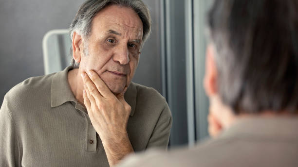 istock Old man looking at his face in the mirror 1431216703