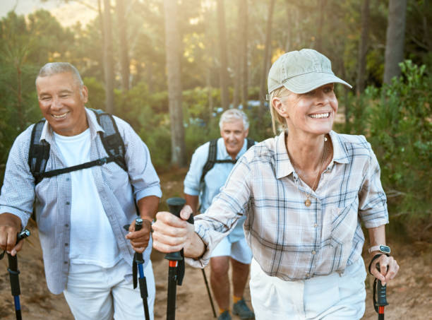 senderismo jubilados, ancianos y amigos mayores o turistas en el bosque o las montañas para el estado físico, la salud y el bienestar en la vejez. grupo diverso de pensionistas maduros activos al aire libre en caminata de fin de semana en la naturaleza - 50 days old fotografías e imágenes de stock