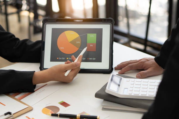istock Businessman analyzing financial statistics displayed on a tablet screen. Business colleagues working and analyzing financial numbers on digital tablets. 1431223804