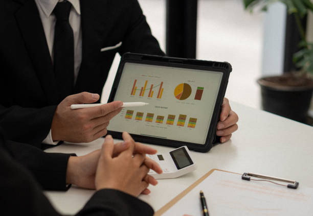 istock Businessman analyzing financial statistics displayed on a tablet screen. Business colleagues working and analyzing financial numbers on digital tablets. 1431223811