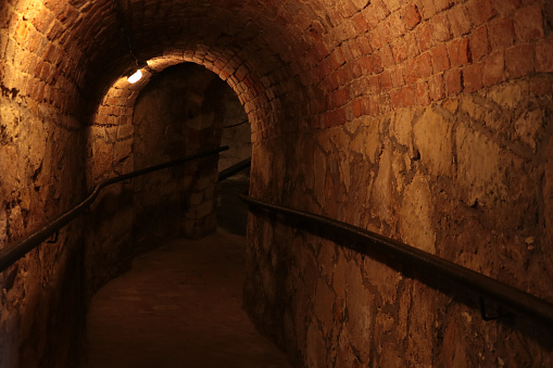 Descent into a dark long basement, stone structure, shelter