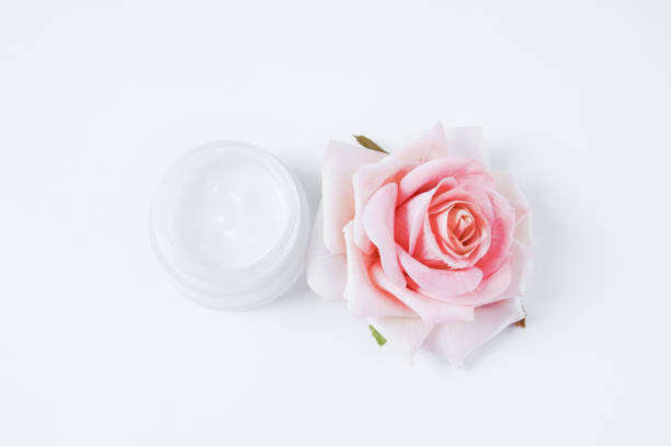 istock jar of face cream and a rose bud on  white background. 1431265326
