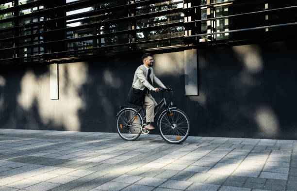 istock Businessman riding bicycle in front of modern office building. 1431267365