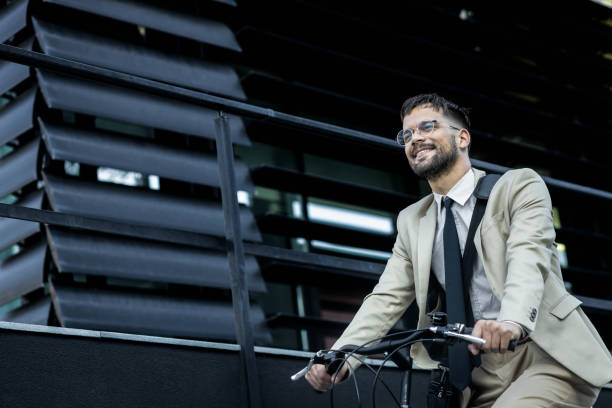 istock Businessman riding bicycle in front of modern office building. 1431267812