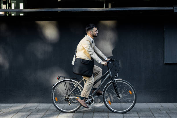 istock Businessman riding bicycle in front of modern office building. 1431268024