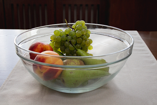 Still life of green fruits on a wooden table, with grapes, apples and pears.