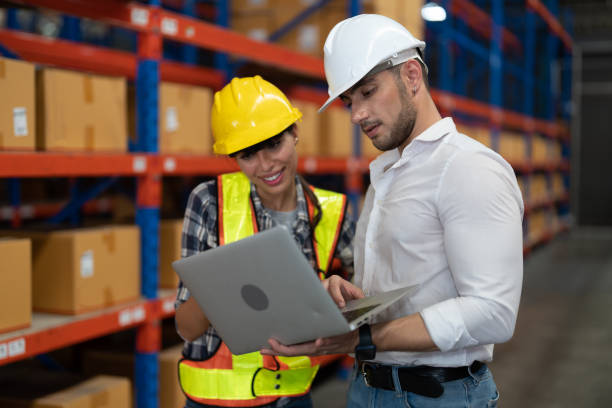istock Supervisor and manager smiling happy holding laptop computer on hand visit warehouse annual audit inventory stock check in large warehouse surrounding with high level of warehouse steel blue racking 1431269576
