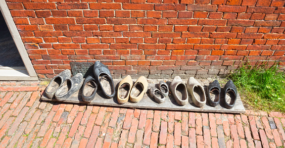Vintage wooden shoes in front of a brick wall in the Netherlands, worn