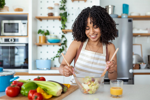 https://media.istockphoto.com/id/1431276724/photo/happy-smiling-cute-woman-is-preparing-a-fresh-healthy-vegan-salad-with-many-vegetables-in-the.jpg?b=1&s=170667a&w=0&k=20&c=Ivl_C0zOKKAuEizTnjHRNPnSW94B_4VrNj2hNlGtq5c=