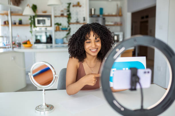 istock Young female influencer using her smart phone for filming a vlog post. 1431278463