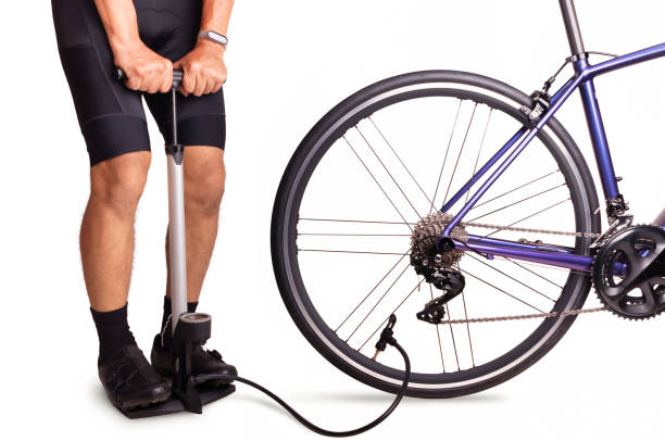 Man inflates the bicycle tire Cyclist using floor pump inflate air into a bicycle wheel. Man inflates the bicycle tire air pump stock pictures, royalty-free photos & images