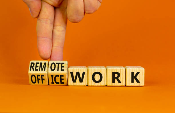 istock Remote or office work symbol. Businessman turns cubes and changes words 'office work' to 'remote work'. Beautiful orange background. Business, remote or office working concept, copy space. 1431281670