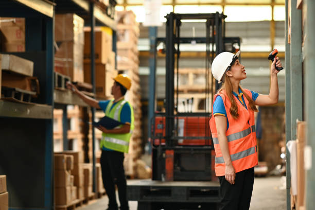 istock Young female warehouse worker using barcode scanner checking stock on shelves in a warehouse. 1431285466