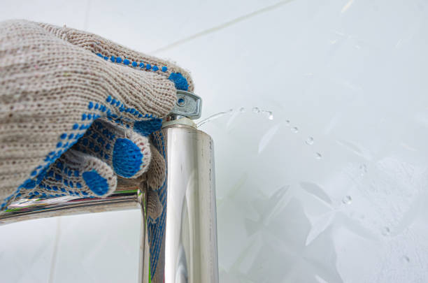 난방 라디에이터의 블리드 밸브. 공기 배출을위한 특수 키가있는 손은 가열 된 수건 레일에서 물과 공기를 배출합니다. - towel hanging bathroom railing 뉴스 사진 이미지
