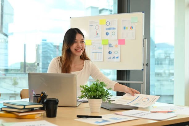 istock Pretty young female employee using laptop and working with financial reports at modern office. 1431286342