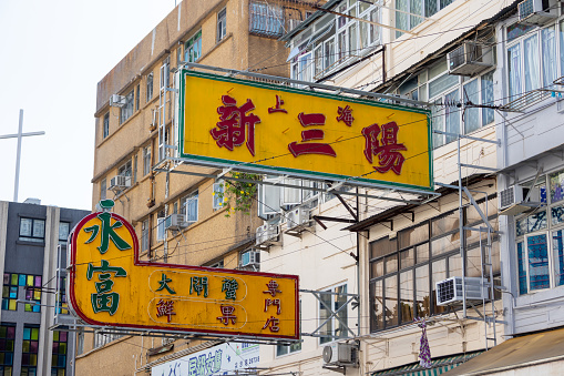 Hong Kong - October 7, 2022 : Shanghai New Sam Yung and Wing Fu Store signboards in Kowloon City, Hong Kong. Signboards that are hanging over the street have been disappearing rapidly in Hong Kong.