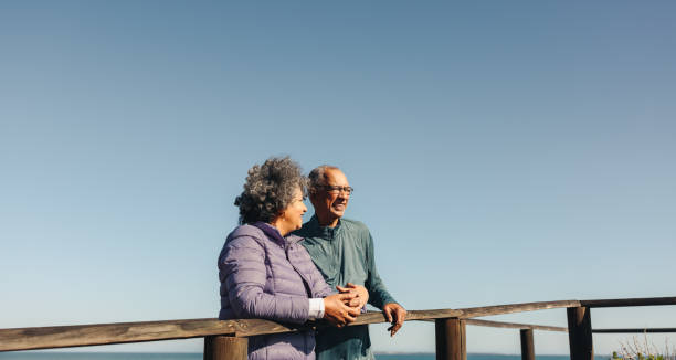 istock Happy elderly couple standing on a wooden seaside bridge 1431293681