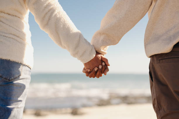 istock Couple holding hands at the beach 1431293820