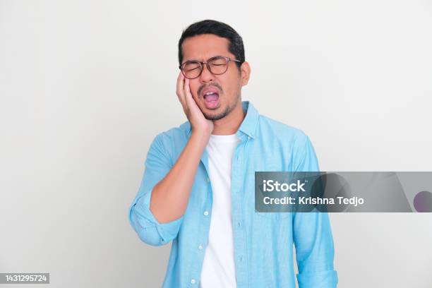 Adult Asian Man Touching His Jaw With Pain Expression Stock Photo - Download Image Now