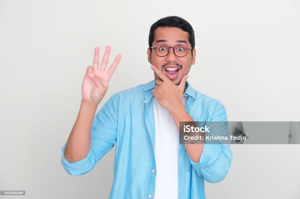 Adult Asian man showing three fingers sign with wow expression Finger Stock Photo