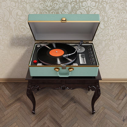 Portable analogue record player or turntable on retro style table.
