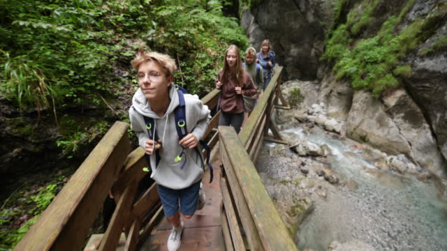 Family hiking on the boardwalk in the mountain river canyon in the in the Alps - Tyrol, Austria.