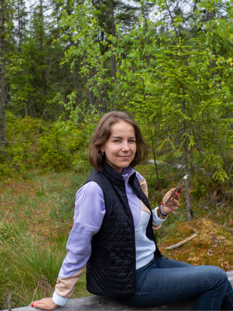 istock woman sitting on fallen tree in a green forest 1431298044
