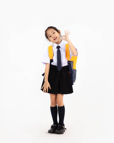istock Asian primary school student kid in uniform with yellow backpack posing on white background. Back to school concept. 1431298114