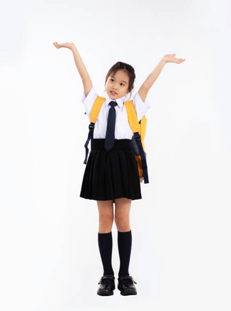 istock Back to school. Asian junior school student in uniform posing on white background. 1431298130