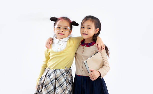 istock Back to school. Little Asian girl students posing on white background. 1431298239