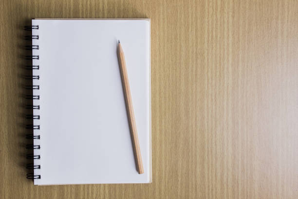 istock White notebook and wooden pen over the wooden table. 1431302838