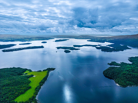 The high angle view across a loch towards a range of hills in Dumfries and Galloway, south west Scotland.\nThe fresh water reservoir is part of the Galloway Hydro Electric Power scheme.
