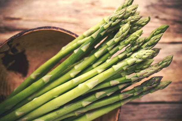 istock Asparagus on the wooden background. 1431309297
