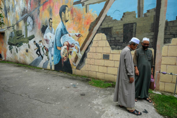 Kota Bharu, Malaysia - October 2022: Two men chatting on a street in Kota Bharu on October 7, 2022 in Kelantan, Malaysia.