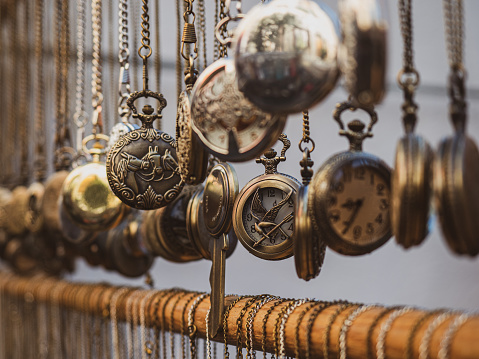 View of many vintage pocket watches for sale in a flea market outdoors.