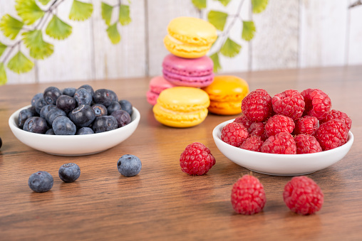 sweet colorful macaroons - small bisquit snacks - with blueberries and raspberries