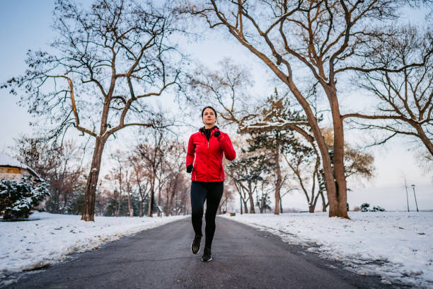 istock Young Woman Running In A Snowy Park 1431317058