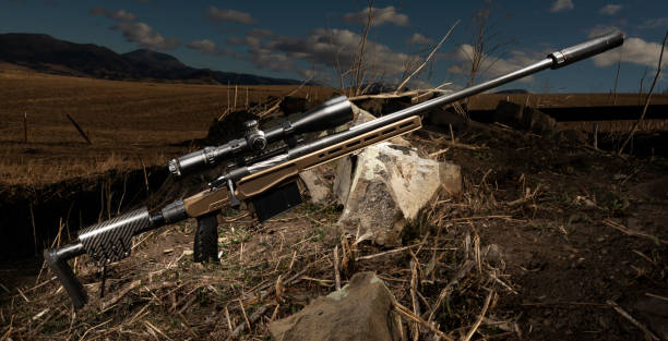 istock Rifle with silencer with rocks in a field 1431319709