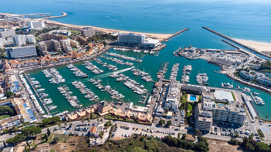 Beautiful aerial perspective of Vilamoura marina. Luxury hotels, yachts docked in the port. Famous travel destination in south of Portugal. Algarve region