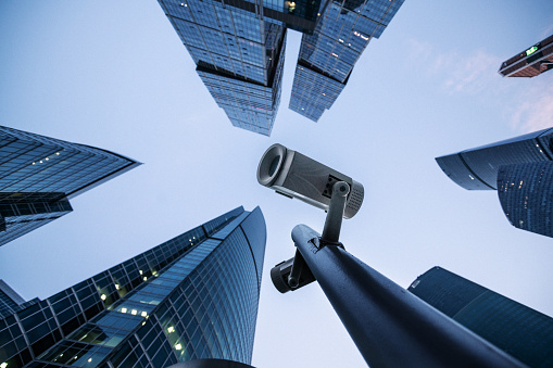 Security camera monitoring system against modern skyscrapers. City safety concept