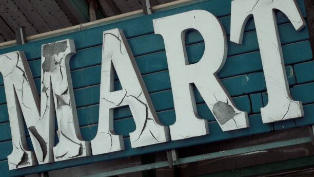 istock Old cracked sign on empty supermarket with peels off letters 1431324113