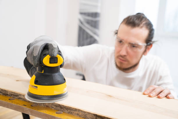 istock carpenter in protective gloves and glasses for working on wood grinding machine 1431328836