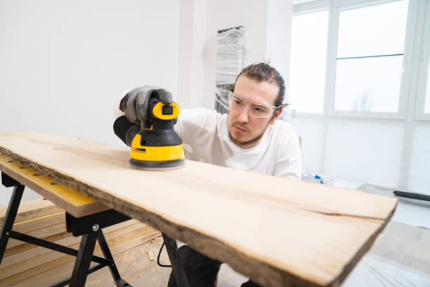 istock carpenter in protective gloves and glasses for working on wood grinding machine 1431328944
