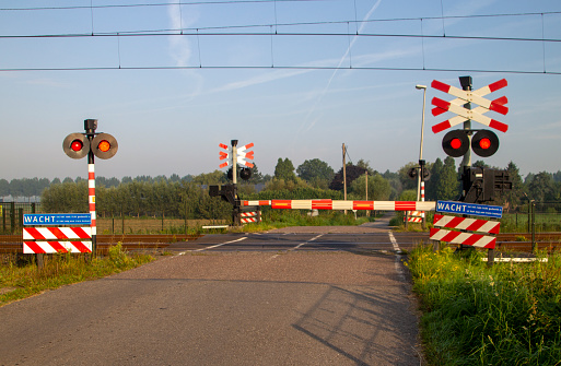 Closed railroad crossing with red lights at the Tweede Tochtweg in Nieuwerkerk aan den IJssel the Netherlands